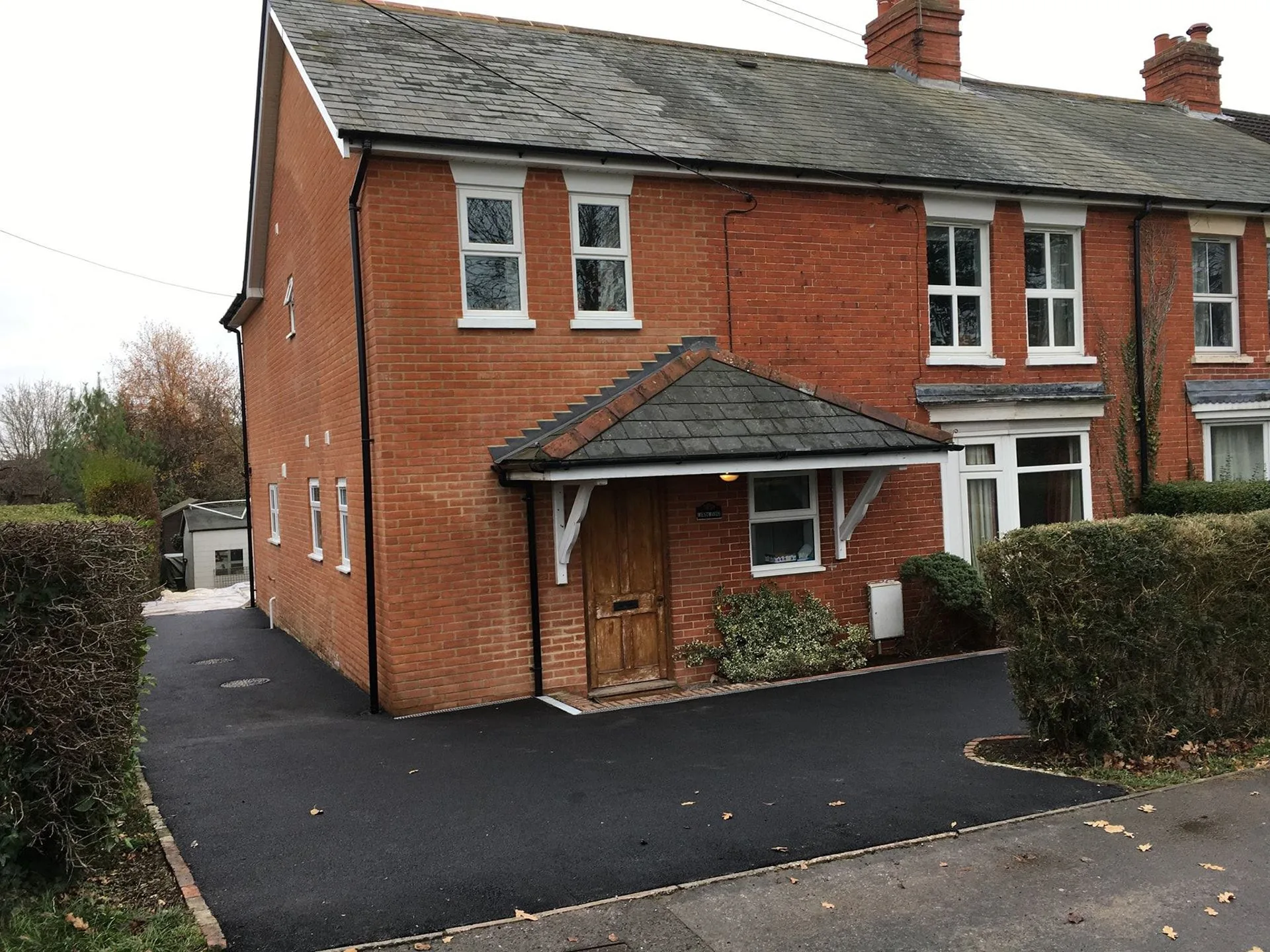 Brick house with a new tiled porch and tarmac driveway