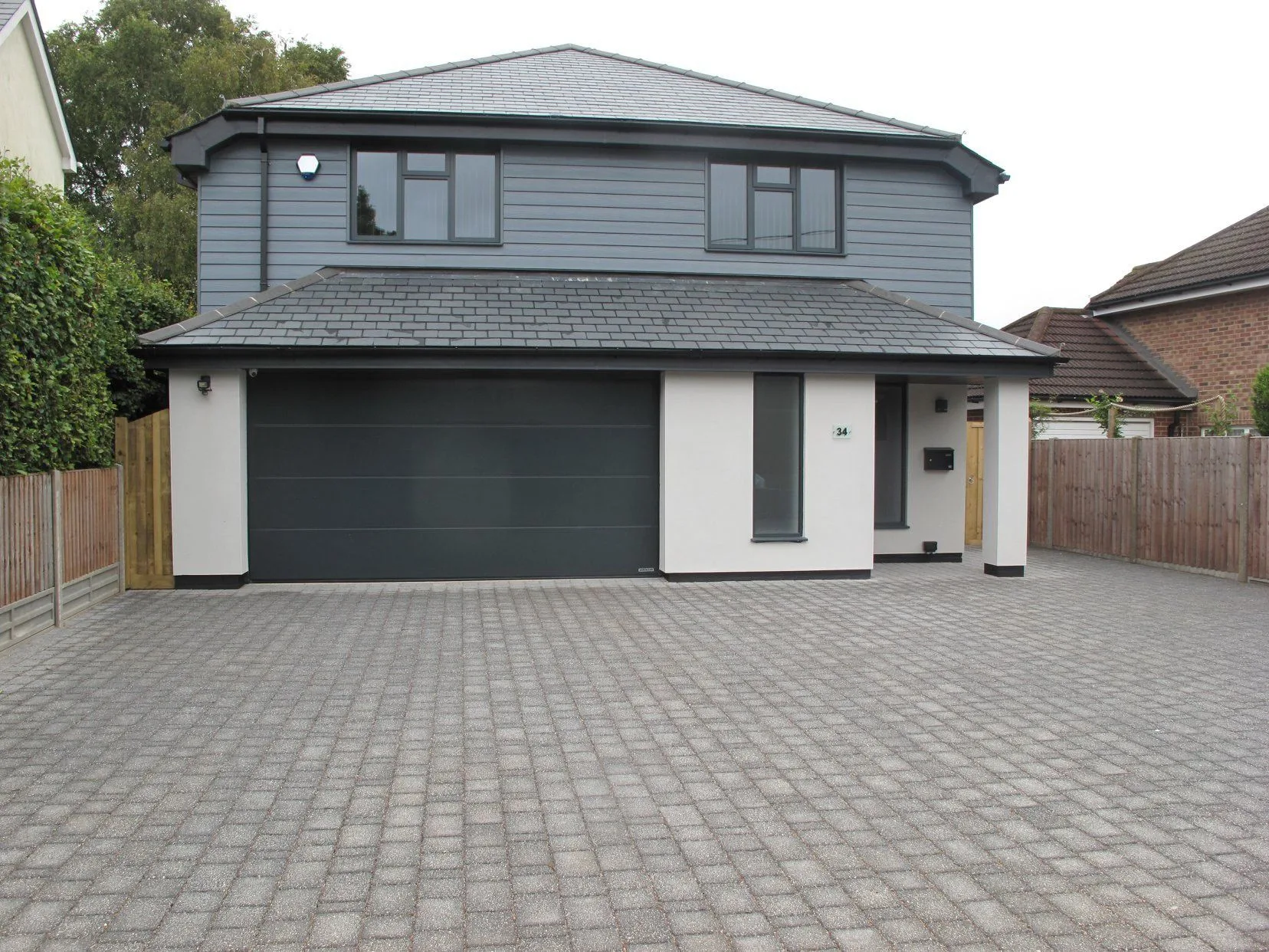 New-build house with grey cladding and a double garage